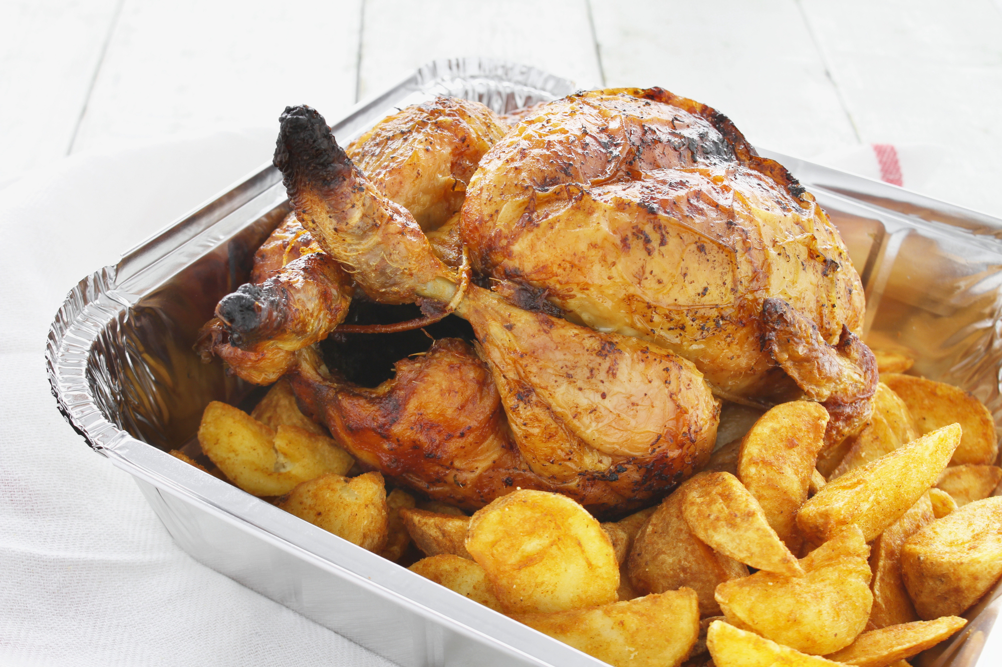 Una vaschetta di pollo arrosto con patate; concept: cibo da asporto, food delivery