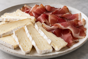 Un piatto di speck e brie a fette